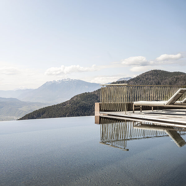 Infinity Pool mit Liegen und Bergblick im 5-Sterne-Designhotel über Bozen